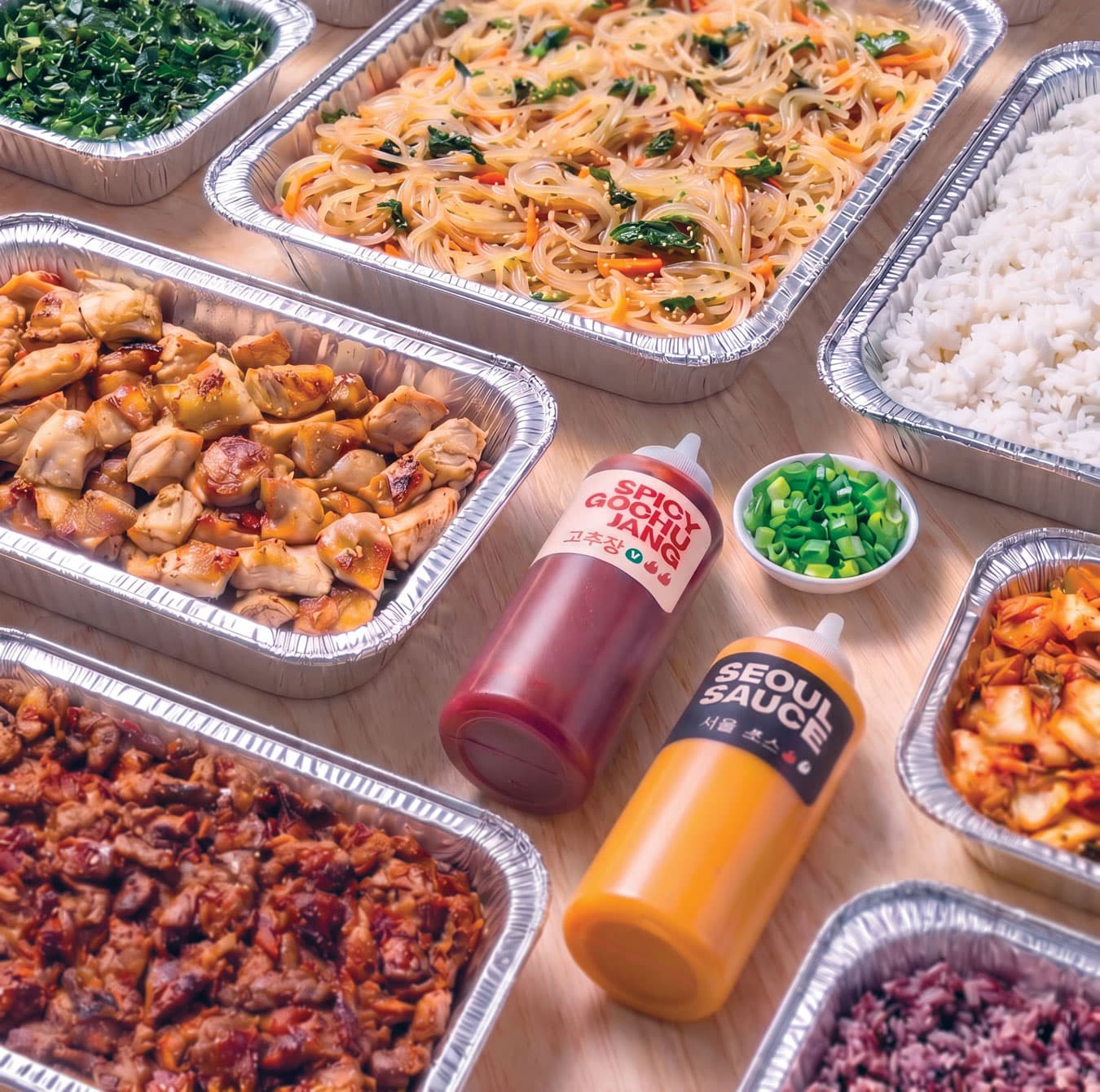 SeoulSpice catering trays of japchae, bulgogi, kimchi and rice with Spicy Gochujang and Seoul Sauce