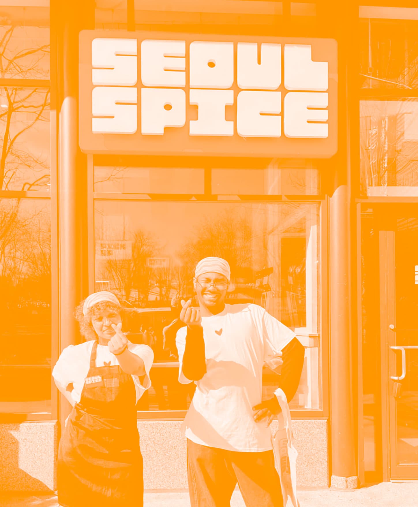 Two SeoulSpice team members throwing finger hearts outside the shop
